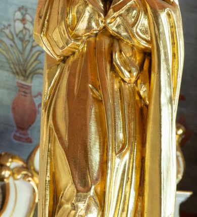 Zdjęcie nr 4: Łuk tęczowy o półkolistym wykroju, na profilowanej belce zdobionej pośrodku ryzowaną rozetą ustawiona grupa Ukrzyżowania. W centrum krucyfiks, po prawej św. Jan Ewangelista, po lewej Matka Boska i św. Maria Magdalena obejmująca krzyż. Chrystus przybity do krzyża trzema gwoździami, sylwetka w delikatnym zwisie, z głową pochyloną delikatnie w dół, o sztywnym układzie sylwetki z zaznaczonymi śladami męki. Perizonium w formie tkaniny przewiązanej na prawym biodrze ze zwisem wzdłuż prawego uda. Twarz podłużna, okolona zarostem; włosy długie spływające na prawe ramię w silnie skręcone pukle, na głowie zielona korona cierniowa złożona z dwóch przeplatających się gałązek. Nad głową Chrystusa biały titulus z napisem: „I(ESUS) N(AZARENUS) R(EX) I(UDAEORUM)”. Krzyż prosty, gładki o ramionach zakończonych gzymsikami. Po lewej stronie krucyfiksu rzeźba św. Marii Magdaleny ukazana w pozycji klęczącej, pochylonej do przodu, obejmująca dłońmi krzyż. Święta jest ubrana w długą, srebrzoną suknię, odsłaniającą nagie ramiona, przewiązaną w talii. Twarz szeroka, delikatnie otwarte usta, małe oczy i długi nos. Głowę okalają długie, ciemne włosy, spływające na plecy. Za nią ustawiona jest rzeźba Matki Boskiej w delikatnym kontrapoście, z prawą nogą ugiętą w kolanie, ze splecionymi na wysokości piersi rękami. Maria jest ubrana w długą, złoconą suknię oraz złocony płaszcz założony na głowę i spływający wzdłuż sylwetki. Twarz szeroka, z wyraźnie zaznaczonym podbródkiem, wzrok skierowany na krucyfiks, zmarszczone brwi. Po prawej stronie rzeźba św. Jana Ewangelisty, ukazanego w postawie stojącej, zwróconego w trzech czwartych w prawo, z rękami splecionymi na wysokości pasa. Twarz owalna, małe usta, długi i wąski nos, wzrok skierowany ku górze, zmarszczone brwi. Włosy ciemne, bujne, spływające na plecy. Święty ubrany jest w długą, złoconą suknię z długimi rękawami. Rzeźby ustawione są na niskich, zielonych cokolikach. Polichromia w odsłoniętych partiach ciała naturalistyczna, detale złocone i srebrzone. 
