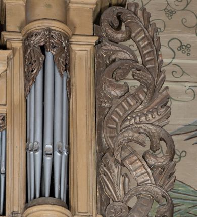 Zdjęcie nr 8: Organy architektoniczne, pięcioosiowe na wysokiej podstawie i niewielkim cokole, trójwieżyczkowe. Wieżyczki boczne niższe od środkowej, wszystkie z półokrągłymi ryzalitami, z prostokątnymi i wypukłymi prześwitami na piszczałki, dekorowanymi w górnych narożach akantem, zakończone fryzem i gzymsem oraz ornamentalnymi szczytami utworzonymi z akantu, karbowanej wstęgi, kampanul i muszli; ryzality u spodu z podwieszonymi kampanulami i muszlą. Szczyt środkowej wieżyczki utworzony z ornamentu małżowinowo-chrząstkowego. Pomiędzy wieżyczkami dwie najniższe osie z prześwitami na piszczałki w formie stojącego prostokąta, zakończone fragmentami gzymsu. Organy ujęte uszami utworzonymi z akantu i karbowanej wstęgi. Struktura polichromowana w całości w kolorze ciemnobeżowym, ornamenty złocone.