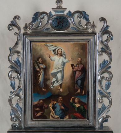 Zdjęcie nr 1: Feretron uzyskał kształt stojącego prostokąta. Tworzy go dwustronnie malowany na płótnie obraz, ujęty w profilowane, srebrzone ramy, ustawiony na postumencie. Ma on formę podłużnego prostopadłościanu, dekorowanego w dolnej i górnej części profilowanymi i srebrzonymi listwami. Dodatkowo zaopatrzono go w parę otworów na drążki umożliwiające noszenie. Całość zdobi niebieskawa marmoryzacja. Ramy z trzech stron otaczają stylizowane, ażurowe i srebrzone wici akantowe. Wić na górnej ramie na środku otacza dwustronny kartusz dekorowany na szczycie cebulastą gałką. W polu kartusza umieszczono na awersie chrystogram "IHS", a na rewersie zawołanie "Ave Maria".    
Na awersie wyobrażono Przemienienie Pańskie na górze Tabor. W środku kompozycji ukazano frontalnie unoszącego się na tle rozjaśnionych obłoków w całej postaci Chrystusa w jasnej szacie. Jego postać została ujęta w kontrapoście z głową w trzech czwartych skierowaną w lewo. Przemieniony Jezusa ma rozłożone ręce na wysokości piersi i nieznacznie założone na siebie nogi z bosymi stopami. Zbawiciel ma owalną, młodzieńczą twarz z krótkim, brązowym zarostem, rumiane policzki oraz wysokie czoło, wydatny nos i usta. Spojrzenie jego dużych oczu skierowane jest w lewo. Głowę otaczają długie, brązowe włosy spływające na ramiona oraz świetlisty nimb. Ubrany jest w jasną tunikę z charakterystycznym, prostopadłym rozcięciem na piersi oraz w płaszcz z silnie rozwianą połą widoczną za głową Jezusa i drugą, mocno udrapowaną, w partii jego nóg. Na tle brązowo-ochrowych obłoków po prawej stronie Chrystusa przedstawiono Mojżesza z tablicami Dekalogu, a po lewej proroka Eliasza. Mojżesz został ukazany z boku w trzech czwartych w kontrapoście z głową widoczną z profilu. Ciężar jego ciała wspiera się na prawej nodze, uniesioną zaś lewą zdaje się podpierać bosą stopą wspartą o palce. O prawe przedramię ma oparte dwie kamienne tablice trzymane prawą ręką. Lewą w geście wskazującym trzyma przy krawędzi jednej z tablic. Patriarcha ma pociągłą twarz otoczoną brązowymi włosami i długą brodą. Ma mocno zaakcentowane oczodoły z brwiami, haczykowaty nos i wydatne usta. Ubrany jest w blado niebieską tunikę odsłaniającą bose stopy i przerzucony przez lewe przedramię jasnoochrowy płaszcz mocno udrapowany z prawej strony. Trzymane przez niego dwie tablice mają kształt wydłużonych, wąskich płyt zakończonych półokrągło z rzymskimi cyframi. Po lewej stronie Chrystusa namalowano Eliasz z księgą w dłoni. Układ jego postaci jest po części odbiciem ułożenia ciała Mojżesza. Eliasz został ukazany w kontrapoście w trzech czwartych z głową odchyloną nieznacznie do tyłu w lewo i spojrzeniem skierowanym ku górze. Ciężar jego ciał wspiera się na prawej nodze, natomiast uniesioną lewą stopę opiera palcami o obłok. W lewej ręce wyciągniętej nieznacznie na wysokości piersi trzyma księgę, prawą zaś przyciska do serca. Prorok ma pociągłą twarz otoczoną siwiejącym, bujnymi włosami i obfitą brodą. Charakteryzują ją rumiane policzki, duży, mięsisty nos i wyraźne usta. Ubrany jest w bladoszkarłatną tunikę z rękawami odsłaniającą bose stopy i ciemnoniebieski płaszcz zarzucony na prawe ramię i osłaniający fragment lewej nogi proroka. U dołu kompozycji w półpostaciach namalowano trzech apostołów. Idąc od lewej ku prawej jest to Jakub, Piotr i Jan Ewangelista. Postać św. Jakuba zajmuje lewy róg obrazu. Apostoł został ukazany frontalnie z głową nieznacznie pochyloną do przodu, którą zdaje się wspierać lewą ręką. Prawą natomiast przyciska do piersi. Ma owalną twarz z widocznymi zakolami, wydatny nos i usta. Jego głowę otaczają brązowe włosy i podobny krótki zarost. Również frontalnie w lekkim kontrapoście namalowano na środku św. Piotra. Apostoł podnosi do góry głowę, kierując spojrzenie na przemienionego Chrystusa. Ma uniesioną ku górze zgiętą w łokciu prawą rękę, lewą natomiast przykłada do piersi. Jego twarz jest pociągła z wysokim czołem, mięsistym nosem i wydatnymi wargami. Otacza ją brązowy zarost. Ubrany jest w niebieską tunikę rozciętą na piersi oraz w przerzucony przez prawe ramie jasnocynobrowy płaszcz. Po prawej stronie św. Piotra ukazano św. Jana ujętego w trzech czwartych z głową ukazaną w profilu, zwróconą w prawo. Jego prawa ręka uniesiona jest w górę na wysokość głowy. Lewa natomiast jest opuszczona ku dołowi. Święty Jan ma duże oczy, mięsisty nos i wargi, a głowę otaczają jasnobrązowe, długie włosy sięgające ramion. Ubrany jest w ciemnozieloną tunikę z dużym dekoltem. Przez ramię ma przerzucony purpurowy płaszcz okrywający fragment widocznego uda podniesionej prawej nogi. Za plecami apostołów widać wierzchołek brunatnej góry oraz fragment lazurowego nieba. 
Na rewersie feretronu umieszczono obraz z Matką Boską z Dzieciątkiem. Marię namalowano frontalnie z Dzieciątkiem, trzymanym na lewym przedramieniu. W prawej opuszczonej ręce Madonna trzyma złociste berło. Ma pociągłą twarz o jasnej karnacji z rumianymi policzkami, z długim, mięsistym nosem oraz wydatne usta. Spojrzenie szeroko otwartych oczu skierowane jest przed siebie. Maria ubrana jest w cimnoniebieski maforion lamowany złotą taśmą okrywający bladoszkarłatną suknię przewiązaną w talii bladozieloną wstążką zawiązaną na kokardę. Na jej głowie widoczna jest zamknięta złota korona zwieńczona globem z krzyżykiem z obręczą dekorowaną malowaną kameryzacją. Wnętrze korony wypełniła czerwona podbitka. Dzieciątko ukazano w trzech czwartych w prawo. Jezus prawą rękę unosi w geście błogosławieństwa w lewej natomiast trzyma glob ziemski ze złotym krzyżykiem. Jego twarz o jasnej karnacji ma wysokie czoło, rumiane policzki, krótki nos i wydatne usta. Głowę, na której ma złotą koronę zamkniętą z globem z krzyżykiem i malowaną kameryzacją, otaczają krótkie brązowe włosy. Jezus ubrany jest w bladoczerwoną tunikę przewiązaną w pasie i odsłaniającą u spodu fragment lewej bosej stopy. Głowy obu postaci otaczają złote nimby z wpisanymi w nie zębatymi  złotymi promieniami. Srebrzyste tło pokrywa złota romboidalna kratownica dekorowana w miejscach przecięć złotymi krzyżykami.      