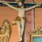 Zdjęcie nr 1: Na niebieskim, drewnianym krzyżu o ramionach wykończonych profilowanymi, złoconymi listwami zawieszono pełnoplastyczną rzeźbę ukrzyżowanego Chrystusa. Ponad jego głową przytwierdzono złocony titulus w formie krótkiej, wygiętej, podłużnej banderoli z inskrypcją &quot;IN / RI&quot;. Ukrzyżowany Chrystus o jasnej karnacji ciała ma ukośnie wyciągnięte, sztywne ręce  o przybitych do krzyża dłoniach oraz założoną nogę prawą na lewą, przytwierdzone jednym gwoździem. Jego ciało jest szczupłe. Ukrzyżowany ma zapadniętą klatkę piersiową, podkreślone żebra i obojczyk. Głowa Jezusa w zielonej koronie cierniowej opada na prawe ramię. Twarz otacza krótki brązowy zarost oraz długie brązowe włosy przykrywające kark i opadające na prawe ramię. Zbawiciel ma zamknięte oczy, prosty nos i wąskie usta. Na czole, szyi, ramionach, przy przebitym boku, dłoniach i stopach oraz na nogach widoczne są stróżki krwi. W partii bioder ciało Chrystusa okrywa przewiązane, złocone perizonium przechodzące w rozwiany feston przy prawym boku.