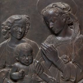 Zdjęcie nr 1: Relief powstał w wyniku odlewu. Uzyskał on kształt stojącego prostokąta ujętego profilowaną ramą. W centrum kompozycji wyobrażono adorującą Matkę Boską Dzieciątko Jezus. Siedzącą w półpostaci Marię ukazano w trzech czwartych w lewo. Jest to młoda kobieta, która na wysokości piersi trzyma złożone modlitewnie dłonie. Na jej kolanach siedzi mały Jezus podtrzymywany przez stojącego za nim młodzieńca. Twarz Madonny charakteryzują miękkie rysy, wysokie czoło, prosty nos i wydatne usta. Spojrzenie jej półprzymkniętych oczu skierowane jest na Jezusa. Falujące włosy otaczające głowę i odsłaniające lewe ucho, ukryte są pod delikatną chustą zawiązaną na głowie, której fragment opada na lewe ramię. Maria ubrana jest w suknię obszytą pod szyją haftowaną taśmą z widoczną na przedzie główką serafina oraz luźny płaszcz opadający miękkimi fałdami na ramię i widoczny fragment oparcia krzesła nożycowego. Nad głową Marii widoczny jest zaznaczony za pomocą lini nimb talerzowy.
Dzieciątko Jezus zostało ukazane frontalnie w mocnym kontrapoście. Jezus prawą rękę zgiętą w łokciu trzyma wysuniętą przed siebie. Natomiast w lewej ułożonej wzdłuż tułowia ma jabłko. Jego owalną twarz charakteryzuje wysokie czoło, wydatny nos i usta. Spojrzenie jego otwartych oczu skierowane jest na widza. Głowę Dzieciątka okalają krótkie włosy odsłaniające uszy. Nagość małego Jezusa okrywa jedynie w części korpusu fragment tkaniny przewiązany w pasie. Dlatego widoczne jest prawe ramię oraz bose nogi od pasa w dół. Siedzącego na kolanach Marii Jezusa obiema rękami podtrzymuje młodzieniec stojący z tyłu z lewej strony kompozycji. Został on ukazany frontalnie z głową ujętą w trzech czwartych w prawo. Ma owalną twarz z wysokim czołem, wydatnym nosem i ustami. Jego głowę otaczają lekko rozwiane kędzierzawe włosy, odsłaniające końcówkę prawego ucha. Ubrany jest w tunikę lamowaną pod szyją i narzucony na ramiona płaszcz. W prawym dolnym rogu kompozycji widoczne jest wolutowe oparcie krzesła nożycowego, zdobione perełkowaniem i stylizowanym liściem akantu.