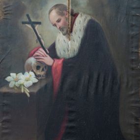 Zdjęcie nr 1: Obraz w kształcie stojącego prostokąta z wizerunkiem św. Jana Kantego. W centrum kompozycji ukazany święty w postawie klęczącej, zwrócony w trzech czwartych w prawo z dłońmi opartymi na czaszce leżącej na stojącym po lewej stronie obrazu klęczniku z podestem. W dłoniach święty trzyma również krucyfiks. Twarz podłużna, z oczami skierowanymi na krucyfiks, z długim i wąskim nosem, okolona średniej długości brodą, policzki silnie zarumienione. Święty ubrany jest w czarną togę akademicką z czerwonym podszyciem, wokół szyi ma gronostajową załogę (pelerynkę). Na klęczniku obok czaszki ułożone są gałązki białej lilii. Tło jednolite w odcieniach zieleni i szarości, w górnej części rozświetlone pochmurne niebo. 