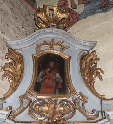 Zdjęcie nr 6: Ołtarz architektoniczny, jednokondygnacyjny, jednoosiowy ze zwieńczeniem. Ołtarz drewniany, sarkofagowy z drewnianą mensą. Retabulum ustawione na zdwojonym cokole o zryzalitowanych bokach. Kondygnacja ujęta jest  parą ustawionych ukośnie do wewnątrz, zdwojonych pilastrów z nałożoną w dolnej partii parą spływów wolutowych, wspierających przełamujący się ponad nimi, silnie wysunięty gzyms. Woluty spływów retabulum zdobione wydatnym rocaille&#039;m oraz parą rokokowych wazonów z gałązkami różyczek. Pole środkowe retabulum w kształcie stojącego prostokąta ujętego dołem odcinkowym łukiem nadwieszonym, od góry zamknięte łukiem wklęsło-wypukłym z uskokami; w polu obraz Matki Nieustającej Pomocy. Trzony pilastrów zdobione podwieszonymi gałązkami z różyczkami, a kapitele ornamentem rocaille&#039;owym. Górną partię środkowego pola retabulum ozdabia ornament rocaille&#039;owy. Zwieńczenie ujęte jest spływami wolutowymi o skośnie ustawionych dolnych partiach, zamknięte odcinkiem gzymsu w kształcie łuku wklęsło-wypukłego. Szczyt zwieńczenia w formie ażurowej, rocaille&#039;owej konchy. Pole środkowe o wklęsłych bokach, ściętych dolnych narożach, zamknięte łukiem wklęsło-wypukłym, ujęte profilowaną złoconą ramą; w środku obraz św. Walentego. Krawędzie spływów wolutowych zdobione parą gałązek palmowych. Struktura polichromowana na biało, cokół w kolorze jasnoszarym z żółtym profilowaniem; partie detalu architektonicznego i ornamentyki złocone i srebrzone.      

