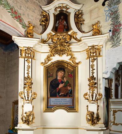 Zdjęcie nr 9: Ołtarz architektoniczny, jednokondygnacyjny, jednoosiowy ze zwieńczeniem. Ołtarz drewniany, sarkofagowy z drewnianą mensą. Retabulum ustawione na zdwojonym cokole o zryzalitowanych bokach. Kondygnacja ujęta jest  parą ustawionych ukośnie do wewnątrz, zdwojonych pilastrów z nałożoną w dolnej partii parą spływów wolutowych, wspierających przełamujący się ponad nimi, silnie wysunięty gzyms. Woluty spływów retabulum zdobione wydatnym rocaille&#039;m oraz parą rokokowych wazonów z gałązkami różyczek. Pole środkowe retabulum w kształcie stojącego prostokąta ujętego dołem odcinkowym łukiem nadwieszonym, od góry zamknięte łukiem wklęsło-wypukłym z uskokami; w polu obraz Matki Nieustającej Pomocy. Trzony pilastrów zdobione podwieszonymi gałązkami z różyczkami, a kapitele ornamentem rocaille&#039;owym. Górną partię środkowego pola retabulum ozdabia ornament rocaille&#039;owy. Zwieńczenie ujęte jest spływami wolutowymi o skośnie ustawionych dolnych partiach, zamknięte odcinkiem gzymsu w kształcie łuku wklęsło-wypukłego. Szczyt zwieńczenia w formie ażurowej, rocaille&#039;owej konchy. Pole środkowe o wklęsłych bokach, ściętych dolnych narożach, zamknięte łukiem wklęsło-wypukłym, ujęte profilowaną złoconą ramą; w środku obraz św. Walentego. Krawędzie spływów wolutowych zdobione parą gałązek palmowych. Struktura polichromowana na biało, cokół w kolorze jasnoszarym z żółtym profilowaniem; partie detalu architektonicznego i ornamentyki złocone i srebrzone.      

