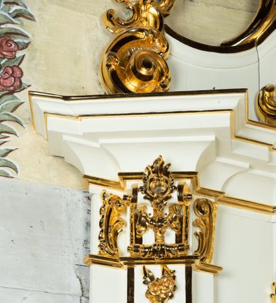 Zdjęcie nr 9: Ołtarz architektoniczny, jednokondygnacyjny, jednoosiowy ze zwieńczeniem. Ołtarz drewniany, sarkofagowy z drewnianą mensą. Retabulum ustawione na zdwojonym cokole o zryzalitowanych bokach. Kondygnacja ujęta jest  parą ustawionych ukośnie do wewnątrz, zdwojonych pilastrów z nałożoną w dolnej partii parą spływów wolutowych, wspierających przełamujący się ponad nimi, silnie wysunięty gzyms. Woluty spływów retabulum zdobione wydatnym rocaille'm oraz parą rokokowych wazonów z gałązkami różyczek. Pole środkowe retabulum w kształcie stojącego prostokąta ujętego dołem odcinkowym łukiem nadwieszonym, od góry zamknięte łukiem wklęsło-wypukłym z uskokami; w polu obraz Matki Boskiej Różańcowej ze św. Dominikiem i św. Katarzyną Sieneńską. Trzony pilastrów zdobione podwieszonymi gałązkami z różyczkami, a kapitele ornamentem rocaille'owym. Górną partię środkowego pola retabulum ozdabia ornament rocaille'owy. Zwieńczenie ujęte jest spływami wolutowymi o skośnie ustawionych dolnych partiach, zamknięte odcinkiem gzymsu w kształcie łuku wklęsło-wypukłego. Szczyt zwieńczenia w formie ażurowej, rocaille'owej konchy. Pole środkowe o wklęsłych bokach, ściętych dolnych narożach, zamknięte łukiem wklęsło-wypukłym, ujęte profilowaną złoconą ramą; w środku obraz św. Antoniego Padewskiego. Krawędzie spływów wolutowych zdobione parą gałązek palmowych. Struktura polichromowana na biało, cokół w kolorze jasnoszarym z żółtym profilowaniem; partie detalu architektonicznego i ornamentyki złocone i srebrzone.      
