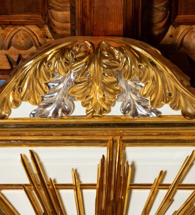 Zdjęcie nr 8: Ołtarz architektoniczny, jednokondygnacyjny, jednoosiowy ze zwieńczeniem. Mensa drewniana, sarkofagowa, ustawiona na parze nóżek w kształcie kul ujętych w górnej partii liśćmi laurowymi z kamiennym portatylem. Na ściance przedniej ozdobiona jest parą płycin w kształcie leżących prostokątów o wklęsłych bokach wewnętrznych; pomiędzy nimi płycina w kształcie koła ze złoconym napisem na niebieskim tle „ALTARE PRIVIL(EGIATUM)”. Retabulum ustawione jest na zdwojonym cokole o zryzalitowanych bokach. Nastawa ujęta parą zdwojonych pilastrów z kapitelami jońskimi, wspierających przełamujące się ponad nimi belkowanie. Pole środkowe retabulum w kształcie stojącego prostokąta, ujęte profilowaną i złoconą ramą z motywem wąskiej szarfy oplatającej cieniutki wałek; w polu obraz Najświętszego Serca Jezusa. Retabulum flankowane jest po bokach parą ażurowych uszaków w formie stylizowanej wici roślinnej z kwiatami. Górną partię trzonów pilastrów zdobi para festonów z liści laurowych, trzony dekorowane są grawerowanymi zwisami w formie gałązek z kwiatami i owocami. W dolnej i górnej partii pola środkowego retabulum ornamentyka rocaille’owa. Gzyms retabulum ozdabia jońska kostka. Zwieńczenie o wklęsłych bokach, ujęte parą wygiętych pilastrów na niewysokich cokołach, podtrzymujących wyłamujące się ponad nimi belkowanie. W polu głównym znajduje się promienista gloria z monogramem maryjnym pośrodku, otoczonym wieńcem z obłoków. Krawędzie boków zdobione są liściastymi gałązkami. Na gzymsie retabulum, po bokach ustawiona jest para aniołków. Struktura ołtarza polichromowana jest w odcieniach szarości, część dolna w kolorze ciemnoszarym, a górna w jasnoszarym; pola płycin antepedium malowane w odcieniach błękitów. Partie detalu architektonicznego i ornamentyka złocone i srebrzone. 
