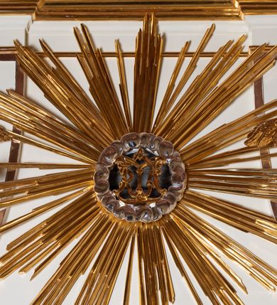 Zdjęcie nr 7: Ołtarz architektoniczny, jednokondygnacyjny, jednoosiowy ze zwieńczeniem. Mensa drewniana, sarkofagowa, ustawiona na parze nóżek w kształcie kul ujętych w górnej partii liśćmi laurowymi z kamiennym portatylem. Na ściance przedniej ozdobiona jest parą płycin w kształcie leżących prostokątów o wklęsłych bokach wewnętrznych; pomiędzy nimi płycina w kształcie koła ze złoconym napisem na niebieskim tle „ALTARE PRIVIL(EGIATUM)”. Retabulum ustawione jest na zdwojonym cokole o zryzalitowanych bokach. Nastawa ujęta parą zdwojonych pilastrów z kapitelami jońskimi, wspierających przełamujące się ponad nimi belkowanie. Pole środkowe retabulum w kształcie stojącego prostokąta, ujęte profilowaną i złoconą ramą z motywem wąskiej szarfy oplatającej cieniutki wałek; w polu obraz Najświętszego Serca Jezusa. Retabulum flankowane jest po bokach parą ażurowych uszaków w formie stylizowanej wici roślinnej z kwiatami. Górną partię trzonów pilastrów zdobi para festonów z liści laurowych, trzony dekorowane są grawerowanymi zwisami w formie gałązek z kwiatami i owocami. W dolnej i górnej partii pola środkowego retabulum ornamentyka rocaille’owa. Gzyms retabulum ozdabia jońska kostka. Zwieńczenie o wklęsłych bokach, ujęte parą wygiętych pilastrów na niewysokich cokołach, podtrzymujących wyłamujące się ponad nimi belkowanie. W polu głównym znajduje się promienista gloria z monogramem maryjnym pośrodku, otoczonym wieńcem z obłoków. Krawędzie boków zdobione są liściastymi gałązkami. Na gzymsie retabulum, po bokach ustawiona jest para aniołków. Struktura ołtarza polichromowana jest w odcieniach szarości, część dolna w kolorze ciemnoszarym, a górna w jasnoszarym; pola płycin antepedium malowane w odcieniach błękitów. Partie detalu architektonicznego i ornamentyka złocone i srebrzone. 
