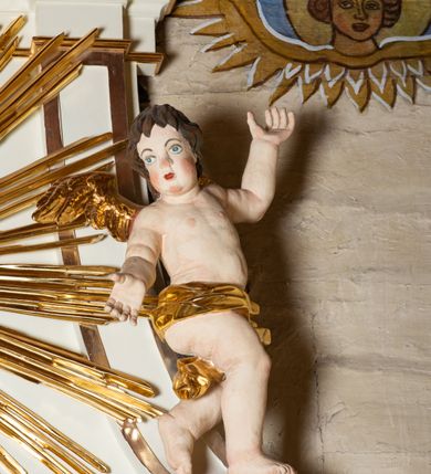 Zdjęcie nr 10: Ołtarz architektoniczny, jednokondygnacyjny, jednoosiowy ze zwieńczeniem. Mensa drewniana, sarkofagowa, ustawiona na parze nóżek w kształcie kul ujętych w górnej partii liśćmi laurowymi z kamiennym portatylem. Na ściance przedniej ozdobiona jest parą płycin w kształcie leżących prostokątów o wklęsłych bokach wewnętrznych; pomiędzy nimi płycina w kształcie koła ze złoconym napisem na niebieskim tle „ALTARE PRIVIL(EGIATUM)”. Retabulum ustawione jest na zdwojonym cokole o zryzalitowanych bokach. Nastawa ujęta parą zdwojonych pilastrów z kapitelami jońskimi, wspierających przełamujące się ponad nimi belkowanie. Pole środkowe retabulum w kształcie stojącego prostokąta, ujęte profilowaną i złoconą ramą z motywem wąskiej szarfy oplatającej cieniutki wałek; w polu obraz Najświętszego Serca Jezusa. Retabulum flankowane jest po bokach parą ażurowych uszaków w formie stylizowanej wici roślinnej z kwiatami. Górną partię trzonów pilastrów zdobi para festonów z liści laurowych, trzony dekorowane są grawerowanymi zwisami w formie gałązek z kwiatami i owocami. W dolnej i górnej partii pola środkowego retabulum ornamentyka rocaille’owa. Gzyms retabulum ozdabia jońska kostka. Zwieńczenie o wklęsłych bokach, ujęte parą wygiętych pilastrów na niewysokich cokołach, podtrzymujących wyłamujące się ponad nimi belkowanie. W polu głównym znajduje się promienista gloria z monogramem maryjnym pośrodku, otoczonym wieńcem z obłoków. Krawędzie boków zdobione są liściastymi gałązkami. Na gzymsie retabulum, po bokach ustawiona jest para aniołków. Struktura ołtarza polichromowana jest w odcieniach szarości, część dolna w kolorze ciemnoszarym, a górna w jasnoszarym; pola płycin antepedium malowane w odcieniach błękitów. Partie detalu architektonicznego i ornamentyka złocone i srebrzone. 
