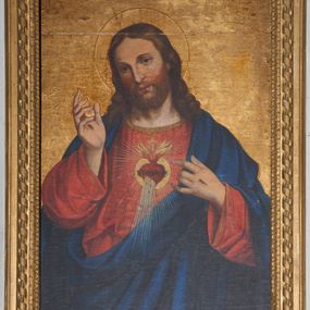 Zdjęcie nr 1: Obraz w kształcie stojącego prostokąta. W centrum kompozycji ukazany jest Chrystus forntalnie w półpostaci, z lewą ręką wskazującą na gorejące na piersi serce, a prawą uniesioną w geście błogosławieństwa. Twarz ma podłużną z długim i wąskim nosem, okoloną krótkim zarostem oraz długimi i bujnymi włosami z przedziałkiem pośrodku, spływającymi na ramiona i plecy. Wokół głowy Chrystus ma złoty i kolisty nimb, a na dłoniach widoczne ślady męki. Zbawiciel ubrany jest w czerwoną suknię z długimi i szerokimi rękawami, zdobioną złotą lamówką na brzegach oraz ciemnoniebieski płaszcz, założony na plecy i przewieszony przez lewe ramię pod prawą rękę. Na piersi Chrystus ma gorejące serce, oplecione koroną cierniową z zatkniętym u szczytu małym krzyżykiem pośród płomieni, ukazane na tle promienistej glorii i kolistego otoku. Tło jednolite, złocone.  Rama drewniana, profilowana, złocona, od wewnątrz zdobiona kimationem, a na zewnątrz motywem laski, okręconej wstążką. 