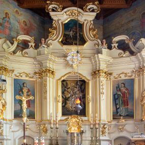 Zdjęcie nr 1: Nastawa ołtarzowa architektoniczna, trójosiowa, jednokondygnacyjna ze zwieńczeniem i bramkami. Ołtarz drewniany, prostopadłościenny; antepedium haftowane. Tabernakulum metalowe, fakturowane, w formie zbliżonej do prostopadłościennej skrzynki, ustawione na niskim cokole, o wypukłej ściance frontowej, flankowane parą kolumn o kompozytowych kapitelach. Drzwiczki w kształcie stojącego prostokąta, zamkniętego łukiem nadwieszonym; w polu kielich z hostią, a po bokach winna winorośl i kłosy zbóż. Powyżej jest tron wystawienia o fantazyjnym kształcie, ujęty po bokach wolutami, na których usadzone są dwa putta. W polu maska lunarna, otoczona promienistą glorią, a w zwieńczeniu muszla palmetowa. Nastawa ustawiona jest na wysokim, zdwojonym cokole, flankowana dwiema parami zdwojonych pilastrów, ustawionych ukośnie. Bramki w kształcie stojących prostokątów, zamkniętych półkoliście, w profilowanej obudowie zwieńczonej wolutowo. Drzwiczki dekorowane są malowanym bukietem kwiatów w wazonie. Kondygnacja o delikatnie wklęsłym przebiegu, ujęta dwiema parami zdwojonych, kanelowanych pilastrów, z których wewnętrzne ustawione są pod kątem. Podpory dźwigają pełne belkowanie, wyłamane nad osiami. Na linii wewnętrznych podpór ustawione są dwa cokoły, na których osadzono dwie główki aniołków, a na linii skrajnych podpór wolutowe przyczółki; z kolei pomiędzy nimi znajdują się fantazyjne woluty. W polu środkowym w ramie o kształcie stojącego prostokąta, zamkniętego łukiem wklęsło-wypukłym z uskokami umieszczony jest obraz Wniebowzięcia Najświętszej Marii Panny, a na zasuwie obraz św. Marcina oraz płótno przedstawiające Chrystusa Ukrzyżowanego. W osiach bocznych obrazy: po lewej św. Szczepan, a po prawej św. Wawrzyniec. Przed skrajnymi podporami ustawione są figury: po lewej św. Piotra, a po prawej św. Pawła. Nad polem głównym zawieszona jest gołębica Ducha Świętego na tle srebrzonych obłoków i promienistej glorii. Zwieńczenie w formie zbliżonej do leżącego prostokąta ujętego spływami wolutowymi, zamknięte profilowanym gzymsem i rocaille’ami. W polu obraz św. Marcina. Struktura polichromowana w kolorze jasnobeżowym, ornamentyka złocona, detale srebrzone.



