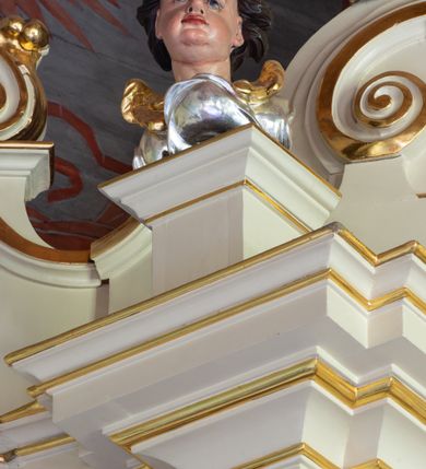 Zdjęcie nr 7: Nastawa ołtarzowa architektoniczna, trójosiowa, jednokondygnacyjna ze zwieńczeniem i bramkami. Ołtarz drewniany, prostopadłościenny; antepedium haftowane. Tabernakulum metalowe, fakturowane, w formie zbliżonej do prostopadłościennej skrzynki, ustawione na niskim cokole, o wypukłej ściance frontowej, flankowane parą kolumn o kompozytowych kapitelach. Drzwiczki w kształcie stojącego prostokąta, zamkniętego łukiem nadwieszonym; w polu kielich z hostią, a po bokach winna winorośl i kłosy zbóż. Powyżej jest tron wystawienia o fantazyjnym kształcie, ujęty po bokach wolutami, na których usadzone są dwa putta. W polu maska lunarna, otoczona promienistą glorią, a w zwieńczeniu muszla palmetowa. Nastawa ustawiona jest na wysokim, zdwojonym cokole, flankowana dwiema parami zdwojonych pilastrów, ustawionych ukośnie. Bramki w kształcie stojących prostokątów, zamkniętych półkoliście, w profilowanej obudowie zwieńczonej wolutowo. Drzwiczki dekorowane są malowanym bukietem kwiatów w wazonie. Kondygnacja o delikatnie wklęsłym przebiegu, ujęta dwiema parami zdwojonych, kanelowanych pilastrów, z których wewnętrzne ustawione są pod kątem. Podpory dźwigają pełne belkowanie, wyłamane nad osiami. Na linii wewnętrznych podpór ustawione są dwa cokoły, na których osadzono dwie główki aniołków, a na linii skrajnych podpór wolutowe przyczółki; z kolei pomiędzy nimi znajdują się fantazyjne woluty. W polu środkowym w ramie o kształcie stojącego prostokąta, zamkniętego łukiem wklęsło-wypukłym z uskokami umieszczony jest obraz Wniebowzięcia Najświętszej Marii Panny, a na zasuwie obraz św. Marcina oraz płótno przedstawiające Chrystusa Ukrzyżowanego. W osiach bocznych obrazy: po lewej św. Szczepan, a po prawej św. Wawrzyniec. Przed skrajnymi podporami ustawione są figury: po lewej św. Piotra, a po prawej św. Pawła. Nad polem głównym zawieszona jest gołębica Ducha Świętego na tle srebrzonych obłoków i promienistej glorii. Zwieńczenie w formie zbliżonej do leżącego prostokąta ujętego spływami wolutowymi, zamknięte profilowanym gzymsem i rocaille’ami. W polu obraz św. Marcina. Struktura polichromowana w kolorze jasnobeżowym, ornamentyka złocona, detale srebrzone.



