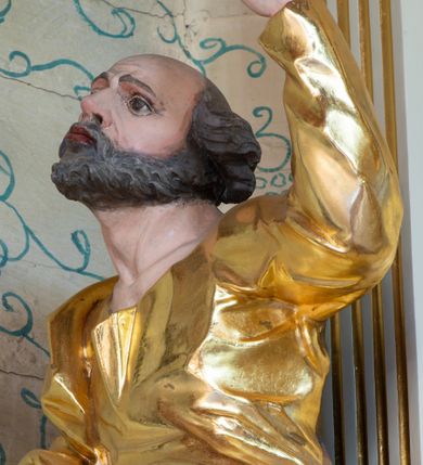 Zdjęcie nr 16: Nastawa ołtarzowa architektoniczna, trójosiowa, jednokondygnacyjna ze zwieńczeniem i bramkami. Ołtarz drewniany, prostopadłościenny; antepedium haftowane. Tabernakulum metalowe, fakturowane, w formie zbliżonej do prostopadłościennej skrzynki, ustawione na niskim cokole, o wypukłej ściance frontowej, flankowane parą kolumn o kompozytowych kapitelach. Drzwiczki w kształcie stojącego prostokąta, zamkniętego łukiem nadwieszonym; w polu kielich z hostią, a po bokach winna winorośl i kłosy zbóż. Powyżej jest tron wystawienia o fantazyjnym kształcie, ujęty po bokach wolutami, na których usadzone są dwa putta. W polu maska lunarna, otoczona promienistą glorią, a w zwieńczeniu muszla palmetowa. Nastawa ustawiona jest na wysokim, zdwojonym cokole, flankowana dwiema parami zdwojonych pilastrów, ustawionych ukośnie. Bramki w kształcie stojących prostokątów, zamkniętych półkoliście, w profilowanej obudowie zwieńczonej wolutowo. Drzwiczki dekorowane są malowanym bukietem kwiatów w wazonie. Kondygnacja o delikatnie wklęsłym przebiegu, ujęta dwiema parami zdwojonych, kanelowanych pilastrów, z których wewnętrzne ustawione są pod kątem. Podpory dźwigają pełne belkowanie, wyłamane nad osiami. Na linii wewnętrznych podpór ustawione są dwa cokoły, na których osadzono dwie główki aniołków, a na linii skrajnych podpór wolutowe przyczółki; z kolei pomiędzy nimi znajdują się fantazyjne woluty. W polu środkowym w ramie o kształcie stojącego prostokąta, zamkniętego łukiem wklęsło-wypukłym z uskokami umieszczony jest obraz Wniebowzięcia Najświętszej Marii Panny, a na zasuwie obraz św. Marcina oraz płótno przedstawiające Chrystusa Ukrzyżowanego. W osiach bocznych obrazy: po lewej św. Szczepan, a po prawej św. Wawrzyniec. Przed skrajnymi podporami ustawione są figury: po lewej św. Piotra, a po prawej św. Pawła. Nad polem głównym zawieszona jest gołębica Ducha Świętego na tle srebrzonych obłoków i promienistej glorii. Zwieńczenie w formie zbliżonej do leżącego prostokąta ujętego spływami wolutowymi, zamknięte profilowanym gzymsem i rocaille’ami. W polu obraz św. Marcina. Struktura polichromowana w kolorze jasnobeżowym, ornamentyka złocona, detale srebrzone.



