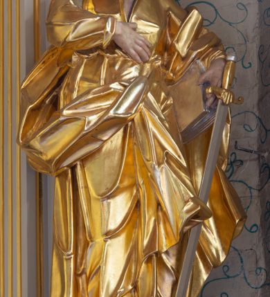 Zdjęcie nr 20: Nastawa ołtarzowa architektoniczna, trójosiowa, jednokondygnacyjna ze zwieńczeniem i bramkami. Ołtarz drewniany, prostopadłościenny; antepedium haftowane. Tabernakulum metalowe, fakturowane, w formie zbliżonej do prostopadłościennej skrzynki, ustawione na niskim cokole, o wypukłej ściance frontowej, flankowane parą kolumn o kompozytowych kapitelach. Drzwiczki w kształcie stojącego prostokąta, zamkniętego łukiem nadwieszonym; w polu kielich z hostią, a po bokach winna winorośl i kłosy zbóż. Powyżej jest tron wystawienia o fantazyjnym kształcie, ujęty po bokach wolutami, na których usadzone są dwa putta. W polu maska lunarna, otoczona promienistą glorią, a w zwieńczeniu muszla palmetowa. Nastawa ustawiona jest na wysokim, zdwojonym cokole, flankowana dwiema parami zdwojonych pilastrów, ustawionych ukośnie. Bramki w kształcie stojących prostokątów, zamkniętych półkoliście, w profilowanej obudowie zwieńczonej wolutowo. Drzwiczki dekorowane są malowanym bukietem kwiatów w wazonie. Kondygnacja o delikatnie wklęsłym przebiegu, ujęta dwiema parami zdwojonych, kanelowanych pilastrów, z których wewnętrzne ustawione są pod kątem. Podpory dźwigają pełne belkowanie, wyłamane nad osiami. Na linii wewnętrznych podpór ustawione są dwa cokoły, na których osadzono dwie główki aniołków, a na linii skrajnych podpór wolutowe przyczółki; z kolei pomiędzy nimi znajdują się fantazyjne woluty. W polu środkowym w ramie o kształcie stojącego prostokąta, zamkniętego łukiem wklęsło-wypukłym z uskokami umieszczony jest obraz Wniebowzięcia Najświętszej Marii Panny, a na zasuwie obraz św. Marcina oraz płótno przedstawiające Chrystusa Ukrzyżowanego. W osiach bocznych obrazy: po lewej św. Szczepan, a po prawej św. Wawrzyniec. Przed skrajnymi podporami ustawione są figury: po lewej św. Piotra, a po prawej św. Pawła. Nad polem głównym zawieszona jest gołębica Ducha Świętego na tle srebrzonych obłoków i promienistej glorii. Zwieńczenie w formie zbliżonej do leżącego prostokąta ujętego spływami wolutowymi, zamknięte profilowanym gzymsem i rocaille’ami. W polu obraz św. Marcina. Struktura polichromowana w kolorze jasnobeżowym, ornamentyka złocona, detale srebrzone.



