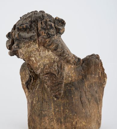 Zdjęcie nr 1: Fragment pełnoplastycznej rzeźby Jezusa Ukrzyżowanego.  Zachował się tors wraz z głową pochyloną na prawy bark. Twarz pociągła z wąskim, prostym nosem, zamkniętymi oczami, wąskimi, lekko rozchylonymi ustami, okolona zarostem i długimi, zwiniętymi w pukle włosami opadającymi na prawe ramię i plecy; na głowie korona cierniowa. 