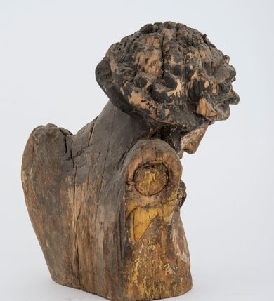 Zdjęcie nr 2: Fragment pełnoplastycznej rzeźby Jezusa Ukrzyżowanego.  Zachował się tors wraz z głową pochyloną na prawy bark. Twarz pociągła z wąskim, prostym nosem, zamkniętymi oczami, wąskimi, lekko rozchylonymi ustami, okolona zarostem i długimi, zwiniętymi w pukle włosami opadającymi na prawe ramię i plecy; na głowie korona cierniowa. 