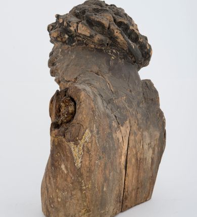 Zdjęcie nr 3: Fragment pełnoplastycznej rzeźby Jezusa Ukrzyżowanego.  Zachował się tors wraz z głową pochyloną na prawy bark. Twarz pociągła z wąskim, prostym nosem, zamkniętymi oczami, wąskimi, lekko rozchylonymi ustami, okolona zarostem i długimi, zwiniętymi w pukle włosami opadającymi na prawe ramię i plecy; na głowie korona cierniowa. 