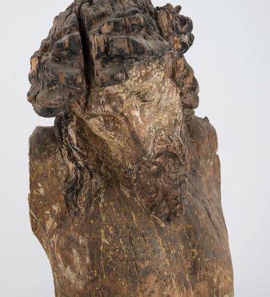 Zdjęcie nr 4: Fragment pełnoplastycznej rzeźby Jezusa Ukrzyżowanego.  Zachował się tors wraz z głową pochyloną na prawy bark. Twarz pociągła z wąskim, prostym nosem, zamkniętymi oczami, wąskimi, lekko rozchylonymi ustami, okolona zarostem i długimi, zwiniętymi w pukle włosami opadającymi na prawe ramię i plecy; na głowie korona cierniowa. 