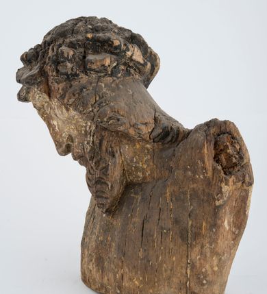 Zdjęcie nr 6: Fragment pełnoplastycznej rzeźby Jezusa Ukrzyżowanego.  Zachował się tors wraz z głową pochyloną na prawy bark. Twarz pociągła z wąskim, prostym nosem, zamkniętymi oczami, wąskimi, lekko rozchylonymi ustami, okolona zarostem i długimi, zwiniętymi w pukle włosami opadającymi na prawe ramię i plecy; na głowie korona cierniowa. 