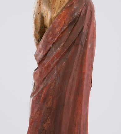Zdjęcie nr 8: Pełnoplastyczna rzeźba św. Jana Ewangelisty stojącego w kontrapoście, z lewą noga ugiętą w kolanie. Święty jest ukazany frontalnie, prawą rękę składa na piersi, w lewej, opuszczonej wzdłuż ciała trzyma zamkniętą księgę. Głowa odchylona do tyłu, twarz podłużna, z prostym nosem, wąskimi ustami, wydatnym podbródkiem, okolona brązowymi włosami, które opadają na ramiona i plecy. Jan jest ubrany w żółtą, rozciętą pod szyją suknię przepasaną w talii oraz czerwony płaszcz zarzucony na prawe ramię i owijający się wokół lewego biodra, opadający prostymi fałdami w dół. Spod tuniki widoczne bose stopy. 