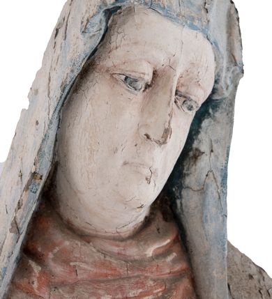 Zdjęcie nr 9: Pełnoplastyczna rzeźba Matki Boskiej Bolesnej ustawionej frontalnie, w lekkim kontrapoście, z prawą nogą ugiętą w kolanie i rękami skrzyżowanymi na piersi. Maria skręca głowę nieznacznie w lewo, spogląda smutno w dół. Na podłużnej twarzy odznaczają się wysokie czoło, duże, migdałowe, półprzymknięte oczy, wąski nos, niewielkie usta oraz szeroki podbródek. Ubrana jest w czerwoną suknię o wąskich, marszczących się równoległymi fałdami rękawach i kołnierzu, spływającą do ziemi podłużnymi fałdami. Na nią nałożony ma jasnoniebieski, zarzucony na głowę płaszcz, który zakrywa plecy i spływa na ramiona. Prawa poła przytrzymana między rękami zawija się przy prawym biodrze łamanymi fałdami. Spod sukni widoczne ciemnobrązowe, szpiczaste buty.