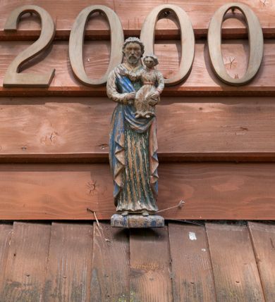 Zdjęcie nr 14: Kościół usytuowany na wzniesieniu, w otoczeniu bogatego drzewostanu. Orientowany, jednonawowy, z zamkniętym trójbocznie prezbiterium i przylegającą od północy zakrystią. Od południa i zachodu do korpusu przylegają kruchty. Nawa na planie prostokąta, szersza od prezbiterium. Wewnątrz pozorne sklepienie kolebkowe, w nawie z płaskimi odcinkami stropowymi po bokach, podpartymi na profilowanych słupach ustawionych na cokołach. Ściany opięte pilastrami naśladującymi formę słupów. Prezbiterium od korpusu oddziela łuk tęczowy, półkolisty, profilowany, ozdobiony ornamentem sznurowym, wsparty na profilowanych kroksztynach dekorowanych drewnianymi rozetami. Od zachodu parapet chóru muzycznego na planie prostokąta oparty na dwóch wielobocznych słupach, front dekorowany motywem w formie powtarzających się zwróconych do siebie par esownic i napisem „MIŁOŚCIĄ WIECZNĄ UMIŁOWAŁEM CIĘ” rozdzielonym wizerunkiem pelikana karmiącego młode własną krwią. Od południa schody prowadzące na chór z analogiczną dekoracją. Fasada prosta, zamknięta daszkiem krytym gontem, zwieńczona trójkątnie. Korpus z trzech stron wzmocniony belkami. Od strony północnej i południowej po dwa okna prostokątne zwieńczone niewielkimi blaszanymi daszkami. Prezbiterium od strony południowej opięte dwoma belkami, z prostokątnym oknem. Na ścianie wschodniej, na zewnątrz, kapliczka z ceramicznym przedstawieniem Matki Boskiej z Dzieciątkiem. W ścianach wschodniej i północnej zakrystii po jednym prostokątnym oknie. Dach dwuspadowy, o jednej kalenicy, od wschodu odzwierciedla układ ścian prezbiterium. Kruchty przykryte dachami dwuspadowymi. Dachy kryte gontem. Na przecięciu korpusu z prezbiterium blaszana, ośmioboczna wieżyczka na sygnaturkę zwieńczona hełmem baniastym ze spłaszczoną kulą z krzyżem. 