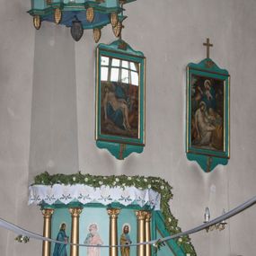 Zdjęcie nr 1: Ambona wisząca, przyścienna, z wejściem od prawej strony w postaci jednobiegowych schodów z balustradą. Kosz na planie koła otoczony kolumnami korynckimi posadowionymi na cokołach i podtrzymującymi belkowanie wyłamane na ich linii. Podwieszenie w formie stożka zakończonego dużą szyszką, dekorowanego plakietami skomponowanymi z elementów floralnych oraz  podwieszonymi szyszkami. Ścianki dekorowane malowanymi przedstawieniami  czterech ewangelistów. 
Baldachim powtarza pomniejszony plan kosza; dekorowany szyszkami, w podniebieniu lampa w kształcie szyszki. W jego zwieńczeniu umieszczono figurą Chrystusa Zbawiciela Świata (Salvator Mundi) na dwustopniowym cokole. Chrystus stoi w kontrapoście, z prawą nogą ugiętą w kolanie i wspartą na kamieniu. Lewą ręką podtrzymuje kulę ziemską zwieńczoną krzyżem, prawą unosi do góry, czyniąc gest błogosławieństwa. Spogląda do góry, ma ciemną brodę i falowane włosy spływające na ramiona i plecy. Z trzech stron głowy odchodzą wiązki promieni. Chrystus ubrany jest w długą, złotą suknię oraz tego samego koloru płaszcz owinięty wokół prawego biodra i przerzucony przez lewą rękę. 