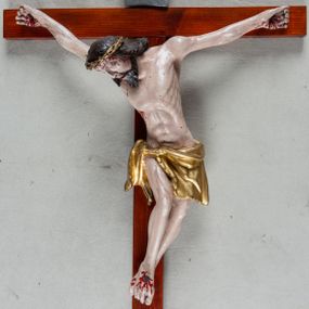 Zdjęcie nr 1: Pełnoplastyczna, polichromowana figura Chrystusa przybitego trzema gwoździami do krzyża łacińskiego. Ciało zmarłego odznacza się drobiazgowym opracowaniem anatomicznym, jest wygięte w łuk tak, że lewe biodro Chrystusa wychodzi poza oś. Na pociągłej twarzy są wyraźnie zaznaczone duże, zamknięte oczy, wąski, długi nos oraz rozchylone usta. Chrystus ma krótki zarost, długie, falowane, ciemnobrązowe włosy opadające na plecy i prawe ramię; na głowie złotą koronę cierniową, spod której spływają strużki krwi. Palce dłoni zwinięte, stopy przybite jednym gwoździem, prawa na lewej; z miejsc przebić oraz z przeciętego boku spływa krew. Wokół bioder owinięte sięgające kolan złote perizonium przewiązane sznurem na prawym biodrze. W dolnej partii pionowej belki srebrzony titulus w formie zwoju, z czarnym napisem „IN/RI”.