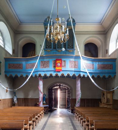 Zdjęcie nr 2: Organy architektoniczne, jednokondygnacyjne, pięcioosiowe na wysokim cokole zdobionym płycinami. Pola kondygnacji wypełnione piszczałkami, w osiach środkowej i bocznych zamknięte prostokątnie z ażurową dekoracją z wici roślinnej w górnej części, pozostałe zamknięte półkoliście. Wyróżnione dekoracją osie są wyższe od pozostałych, podtrzymują kawałki belkowania o silnie wysuniętym gzymsie i mają półkoliste zwieńczenia. Boczne przerwane na środku postumentami z wazonami, środkowe z  dekoracją z wolut i akantu oraz zatkniętym na szczycie krzyżem. 
Struktura polichromowana w kolorze niebieskim; ornamentyka i profile złocone.