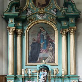 Zdjęcie nr 1: Ołtarz architektoniczny, jednokondygnacyjny, jednoosiowy ze zwieńczeniem. Nastawa na pięciodzielnym cokole o uskokowych bokach. Pierwsza kondygnacja retabulum ujęta dwoma parami kolumn o kanelowanych trzonach i korynckich kapitelach, z których przednie wysunięte na zewnątrz wspierają przerwane, wyłamujące się ponad nimi belkowanie z silnie wysuniętym gzymsem. Pole środkowe wypełnia rama w kształcie stojącego prostokąta zamkniętego łukiem półkolistym z obrazem Matki Boskiej Różańcowej, ponad którą uskrzydlona głowa aniołka. Zwieńczenie retabulum o wklęsłych bokach ujęte parą spływów wolutowych, zamknięte odcinkiem gzymsu w formie łuku odcinkowego nadwieszonego, flankowane odcinkami przerwanego, wklęsło-wypukłego naczółka. Pole zwieńczenia w kształcie stojącego owalu z przedstawieniem Ecce Homo, poniżej którego dwie uskrzydlone główki anielskie. Na fragmentach przyczółka para siedzących aniołków. Szczyt w formie promienistej glorii z monogramem maryjnym na tle srebrzonych obłoków flankowany parą płonących wazonów. 
Retabulum zdobione ornamentyką roślinną z motywem wici w dolnej partii, akantu wokół ram obrazowych, rozetek na fryzie i kampanul wypełniających spływy. 
Struktura polichromowana w odcieniach zieleni. Detal architektoniczny i ornamentyka złocone i srebrzone. Aniołki polichromowane naturalistycznie. 
