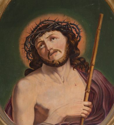 Zdjęcie nr 1: Owalny obraz z przedstawieniem Chrystusa w typie Ecce Homo. Jezus ukazany w półfigurze, zwrócony w trzech czwartych w lewo. Prawą ręką przytrzymuje trzcinę, lewą ma schowaną pod płaszczem. Wznosi wzrok ku górze, ma owalną, okoloną zarostem twarz, ciemne oczy, wąski nos oraz rozchylone usta. Długie, jasnobrązowe włosy spływają mu na plecy i lewe ramię. Na głowie korona cierniowa, wokół której rozświetlony na czerwono nimb. Purpurowy, przerzucony przez lewe ramię płaszcz spływa gęstymi fałdami w dół. Tło ciemnozielone.
