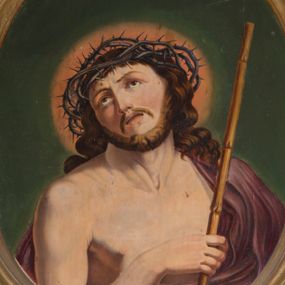 Zdjęcie nr 1: Owalny obraz z przedstawieniem Chrystusa w typie Ecce Homo. Jezus ukazany w półfigurze, zwrócony w trzech czwartych w lewo. Prawą ręką przytrzymuje trzcinę, lewą ma schowaną pod płaszczem. Wznosi wzrok ku górze, ma owalną, okoloną zarostem twarz, ciemne oczy, wąski nos oraz rozchylone usta. Długie, jasnobrązowe włosy spływają mu na plecy i lewe ramię. Na głowie korona cierniowa, wokół której rozświetlony na czerwono nimb. Purpurowy, przerzucony przez lewe ramię płaszcz spływa gęstymi fałdami w dół. Tło ciemnozielone.