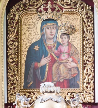 Zdjęcie nr 2: Ołtarz architektoniczny, przyścienny, jednokondygnacyjny ze zwieńczeniem i bramkami, ustawiony na dwóch stopniach. 
Na mensie tabernakulum i znajdujący się nad nim tron wystawienia na rzucie kwadratu o ściętych ćwierćkoliście narożach. Całość ujęta usadowionymi na wysokich cokołach kolumienkami dźwigającymi odcinki belkowania ze wspólnym gzymsem będące jednocześnie podstawami dla figur klęczących i stojących aniołów. W wieńczeniu półsferyczna kopuła dekorowana girlandami kwiatowymi zwieńczona księgą z siedmioma pieczęciami, na której leży baranek. 
Nastawa ołtarzowa architektoniczna, przyścienna, jednokondygnacyjna ze zwieńczeniem, jednoosiowa z bramkami, na dwustrefowym cokole. Ujęta dwiema parami kolumn o kanelowanych na wysokości dwóch trzecich trzonach i kapitelach kompozytowych, rozdzielonych półfilarami z gablotami wypełnionymi wotami, podtrzymującymi wyłamane na ich osi belkowanie. W polu środkowym nisza w formie stojącego prostokąta zamkniętego łukiem półkolistym mieszcząca obraz Matki Boskiej Śnieżnej. Zwieńczenie w formie trzymanego przez dwa anioły baldachimu z podwieszonym płaszczem królewskim z podbiciem gronostajowym i złotą lamówką, z gzymsem z podwieszonymi lambrekinami. Na płaszczu umieszczono monogram Marii. Na skraju belkowania para klęczących na podstawie aniołów. Bramki w formie arkad z kluczem, zwieńczone dwoma spływami wolutowymi stanowiącymi podstawę dla cokołów na figury św. Piotra i św. Pawła. Na cokołach kolumn wieńce laurowe, w partii fryzu rozety i przeplatająca się wić roślinna, w pachach rozety z wicią roślinną. Struktura polichromowana w kolorze seledynowym; kolumny, profile i ornamentyka złocone i srebrzone, anioły polichromowane naturalistycznie. 