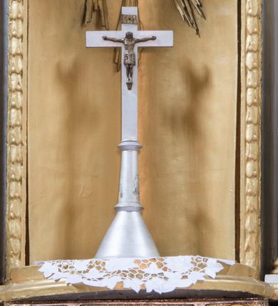 Zdjęcie nr 5: Ołtarz architektoniczny, przyścienny, jednokondygnacyjny ze zwieńczeniem i bramkami, ustawiony na dwóch stopniach. 
Na mensie tabernakulum i znajdujący się nad nim tron wystawienia na rzucie kwadratu o ściętych ćwierćkoliście narożach. Całość ujęta usadowionymi na wysokich cokołach kolumienkami dźwigającymi odcinki belkowania ze wspólnym gzymsem będące jednocześnie podstawami dla figur klęczących i stojących aniołów. W wieńczeniu półsferyczna kopuła dekorowana girlandami kwiatowymi zwieńczona księgą z siedmioma pieczęciami, na której leży baranek. 
Nastawa ołtarzowa architektoniczna, przyścienna, jednokondygnacyjna ze zwieńczeniem, jednoosiowa z bramkami, na dwustrefowym cokole. Ujęta dwiema parami kolumn o kanelowanych na wysokości dwóch trzecich trzonach i kapitelach kompozytowych, rozdzielonych półfilarami z gablotami wypełnionymi wotami, podtrzymującymi wyłamane na ich osi belkowanie. W polu środkowym nisza w formie stojącego prostokąta zamkniętego łukiem półkolistym mieszcząca obraz Matki Boskiej Śnieżnej. Zwieńczenie w formie trzymanego przez dwa anioły baldachimu z podwieszonym płaszczem królewskim z podbiciem gronostajowym i złotą lamówką, z gzymsem z podwieszonymi lambrekinami. Na płaszczu umieszczono monogram Marii. Na skraju belkowania para klęczących na podstawie aniołów. Bramki w formie arkad z kluczem, zwieńczone dwoma spływami wolutowymi stanowiącymi podstawę dla cokołów na figury św. Piotra i św. Pawła. Na cokołach kolumn wieńce laurowe, w partii fryzu rozety i przeplatająca się wić roślinna, w pachach rozety z wicią roślinną. Struktura polichromowana w kolorze seledynowym; kolumny, profile i ornamentyka złocone i srebrzone, anioły polichromowane naturalistycznie. 