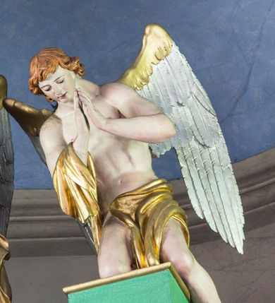 Zdjęcie nr 4: Ołtarz architektoniczny, przyścienny, jednokondygnacyjny ze zwieńczeniem i bramkami, ustawiony na dwóch stopniach. 
Na mensie tabernakulum i znajdujący się nad nim tron wystawienia na rzucie kwadratu o ściętych ćwierćkoliście narożach. Całość ujęta usadowionymi na wysokich cokołach kolumienkami dźwigającymi odcinki belkowania ze wspólnym gzymsem będące jednocześnie podstawami dla figur klęczących i stojących aniołów. W wieńczeniu półsferyczna kopuła dekorowana girlandami kwiatowymi zwieńczona księgą z siedmioma pieczęciami, na której leży baranek. 
Nastawa ołtarzowa architektoniczna, przyścienna, jednokondygnacyjna ze zwieńczeniem, jednoosiowa z bramkami, na dwustrefowym cokole. Ujęta dwiema parami kolumn o kanelowanych na wysokości dwóch trzecich trzonach i kapitelach kompozytowych, rozdzielonych półfilarami z gablotami wypełnionymi wotami, podtrzymującymi wyłamane na ich osi belkowanie. W polu środkowym nisza w formie stojącego prostokąta zamkniętego łukiem półkolistym mieszcząca obraz Matki Boskiej Śnieżnej. Zwieńczenie w formie trzymanego przez dwa anioły baldachimu z podwieszonym płaszczem królewskim z podbiciem gronostajowym i złotą lamówką, z gzymsem z podwieszonymi lambrekinami. Na płaszczu umieszczono monogram Marii. Na skraju belkowania para klęczących na podstawie aniołów. Bramki w formie arkad z kluczem, zwieńczone dwoma spływami wolutowymi stanowiącymi podstawę dla cokołów na figury św. Piotra i św. Pawła. Na cokołach kolumn wieńce laurowe, w partii fryzu rozety i przeplatająca się wić roślinna, w pachach rozety z wicią roślinną. Struktura polichromowana w kolorze seledynowym; kolumny, profile i ornamentyka złocone i srebrzone, anioły polichromowane naturalistycznie. 