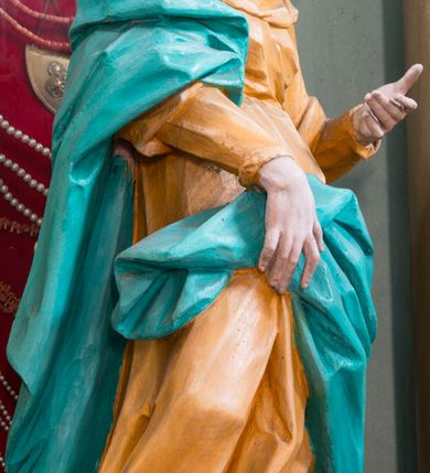 Zdjęcie nr 3: Rzeźba pełna, ustawiona na niewielkim cokole. Figura ukazana w całej postaci, zwrócona w trzech czwartych w lewo, w silnym kontrapoście, o esowato wygiętej sylwetce. Głowa delikatnie pochylona, skierowana w lewo; lewa ręka ugięta i uniesiona, prawa opuszczona z przodu, podtrzymuje płaszcz. Twarz szczupła, o wyraźnie zaznaczonej linii brody i kości policzkowych, oczy duże, płytko rzeźbione, nos niewielki. Święta jest ubrana w sięgającą ziemi,  żółtą suknię, przepasaną w talii, z wąskimi rękawami oraz dużym dekoltem z wywiniętą partią draperii przy brzegu. Tkanina przylega do ciała, jest marszczona w partii torsu i drapowana dołem w grube, pojedyncze fałdy. Turkusowy płaszcz przerzucony przez prawe przedramię opada przez plecy na lewy bok, z podtrzymywaną z przodu partią tkaniny, draperia silnie fałdowana. Na głowie długi, biały welon opadający na plecy. Polichromia naturalistyczna.
