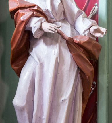 Zdjęcie nr 1: Rzeźba pełna, posadowiona na niskim cokole. Święty ukazany całopostaciowo, zwrócony w prawo, w silnym kontrapoście z prawą nogą odsuniętą do tyłu, z głową ukazaną z profilu, skierowaną w prawo. Obie ręce zwrócone w lewą stronę. Twarz szczupła, pociągła, o wydatnym, wąskim nosie i płytkich oczodołach, okolona długą gęstą brodą i krótkimi układającymi się w pukle włosami jakby rozwianymi do tyłu. Postać jest ubrana w jasną suknię sięgającą stóp, o dużym dekolcie odsłaniającym ramiona. Tkanina przylega do ciała, drapowana jest w grube, pojedyncze fałdy. Okrywający plecy brązowy płaszcz przerzucony przez prawe ramię i lewe biodro jest spięty taśmą na przodzie. Polichromia naturalistyczna.