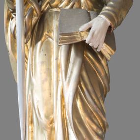 Zdjęcie nr 1: Rzeźba pełna, ustawiona na niewysokim cokole. Postać ukazana w całej postaci, zwrócona frontalnie, w delikatnym kontrapoście, z lewą nogą wystawioną do przodu. Głowa skierowana lekko w prawo, przechylona na bok i uniesiona; twarz owalna, szczupła, okolona gęstym zarostem; wzrok zwrócony do góry. Włosy półdługie, kręcone, opadają na plecy. W prawej, zgiętej ręce święty trzyma miecz, lewą przytrzymuje na biodrze otwartą księgę. Apostoł jest ubrany w suknię sięgającą ziemi, przewiązaną w talii; tkanina obficie drapowana w miękkie, drobne fałdki podkreśla układ ciała. Płaszcz przerzucony przez prawe przedramię owija się wokół lewego biodra. Polichromia naturalistyczna w odsłoniętych partiach ciała, szaty i atrybuty złocone i srebrzone.