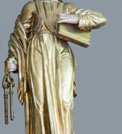 Zdjęcie nr 1: Rzeźba pełna, ustawiona na niewielkim cokole. Figura ukazana w całej postaci, zwrócona frontalnie, w delikatnym kontrapoście. Głowa skierowana lekko w lewo, uniesiona; twarz owalna, szczupła, okolona gęstym zarostem, wzrok zwrócony w górę. Włosy półdługie, kręcone, opadające na plecy. W prawej, opuszczonej wzdłuż ciała ręce święty trzyma klucze, lewą przytrzymuje zamkniętą księgę. Apostoł jest ubrany w suknię sięgającą ziemi, przewiązaną w talii; obficie drapowana w miękkie, drobne fałdki tkanina podkreśla układ ciała. Płaszcz przerzucony przez prawe przedramię opada na plecy. Polichromia naturalistyczna w odsłoniętych partiach ciała, szaty i atrybuty złocone.