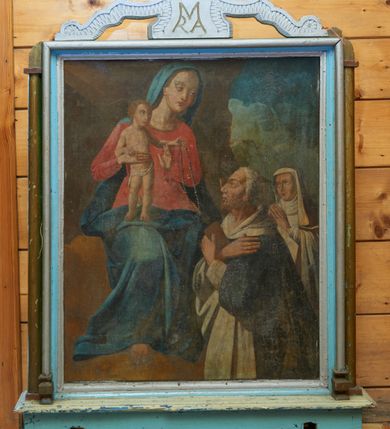 Zdjęcie nr 1: Feretron z obrazami Matki Boskiej Różańcowej oraz Koronacji Marii, ustawiony na prostopadłościennej podstawie z małym cokolikiem i zamkniętej prostym gzymsem. Podstawa zaopatrzona jest w otwory na drążki do noszenia. Obrazy ujęte są w prostokątne ramy, po bokach flankowane wąskimi półkolumienkami. Zwieńczenie w formie wielobocznego medalionu z monogramem maryjnym (po drugiej stronie feretronu monogramem IHS), od którego odchodzą dwa spływy wolutowe, dekorowane karbowaną płyciną. Na szczycie zatknięty jest mały krzyżyk, zdobiony kółeczkami. 

Po jednej stronie feretronu przedstawiona jest Matka Boska Różańcowa ze świętymi dominikańskimi. Matka Boska została ukazana po lewej stronie obrazu w pozycji siedzącej, zwrócona delikatnie w lewo z Dzieciątkiem Jezus stojącym na jej prawym kolanie. Maria głowę przechyla na lewą stronę i kieruje swój wzrok na klęczących przed nią św. Dominikiem i św. Katarzyną ze Sieny. Matka Boska ma owalną twarz z drobnymi ustami, długim nosem i dużymi oczami; długie i ciemnobrązowe włosy; a także smukłe dłonie. schowane są pod niebieskim welonem. Maria ubrana jest w czerwoną suknię z długimi rękawami, przewiązaną w talii oraz ciemnoniebieski płaszcz, zasłaniający plecy i nogi. Dzieciątko ukazane jest frontalnie w pozycji stojącej z głową zwróconą w lewą stronę. Prawą rękę opiera na dłoni Matki, a lewą przekazuje różaniec św. Dominikowi. Ma owalną twarz z małymi ustami, spiczastym nosem i dużymi oczami, włosy jasne, krótkie i kędzierzawe. Wokół bioder ma wąską i luźno opadającą pieluszkę. Po prawej stronie kompozycji klęczy św. Dominik, ukazany w półpostaci, zwrócony w prawo z rękami skrzyżowanymi na piersi, w prawej dłoni trzyma książeczkę w brązowej oprawie. Święty ma rysy twarzy starszego mężczyzny z siwą i krótką brodą oraz siwymi włosami. Ubrany jest w habit i płaszcz dominikański. Za nim klęczy, zwrócona trzy czwarte w prawo św. Katarzyna ze Sieny z dłońmi złożonymi w geście modlitwy i wzrokiem wpatrzonym na Matkę Boską. Święta ma owalną twarz z małymi ustami, długim nosem i dużymi oczami. Ubrana jest w habit, płaszcz i welon dominikański. Po lewej stronie obrazu tło jest brązowe ze snopem światła padającym z lewego, górnego naroża, a po prawej stronie obrazu widoczne jest pochmurne szaro-niebieskie niebo. 

Po drugiej stronie feretronu znajduje się obraz przedstawiający Koronację Matki Boskiej. Pośrodku klęcząca Maria z rękami skrzyżowanymi na piersiach, z głową zwróconą w prawo. Ma podłużną twarz z małymi ustami, długim nosem, dużymi oczami ze wzrokiem skierowanym w dół. Jej długie i jasnobrązowe włosy spływają na plecy. Ubrana jest w czerwoną suknię z długimi rękawami oraz ciemnoniebieski płaszcz założony na prawe ramię. Po prawej stronie obrazu znajduje się siedzący Bóg Ojciec, prawą ręką trzymający koronę nad głową Marii z lewą ręką wspartą na niebieskim globie ziemskim i berłem w lewej dłoni. Twarz o rysach starszego mężczyzny, okolona długą i siwą brodą oraz krótkimi i siwymi włosami. Ubrany jest w szarą, długą suknię oraz ciemnobrązowy płaszcz z szarą podszewką. Wokół głowy ma złoty i trójkątny nimb. Po lewej stronie obrazu jest ukazany Chrystus w pozycji siedzącej, zwrócony trzy czwarte w lewo, lewą ręką podtrzymujący koronę nad głową Marii, a w prawej dzierżący wysoki krzyż. Twarz podłużna, okolona krótką i brązową brodą oraz długimi włosami, spływającymi na plecy i ramiona. Ubrany jest w czerwony płaszcz, odsłaniający nagi tors. W górnej części obrazu gołębica Ducha Świętego z rozpostartymi szeroko skrzydłami, od której odchodzą promienie światła. Korona na głową Marii czerwona, zamknięta, zwieńczona krzyżykiem. Całość ukazana na tle złotego nieba i złotych obłoków, w narożach ciemne chmury. 