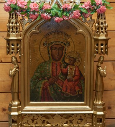 Zdjęcie nr 2: Feretron dwustronny z obrazami Matki Boskiej Częstochowskiej oraz św. Antoniego Padewskiego. Konstrukcja feretronu osadzona na dwóch nóżkach na planie koła, wspierających dwa wieloboczne w rzucie cokoły, połączone listwami stabilizującymi konstrukcję feretronu; cokoły zaopatrzone są w otwory na drążki do noszenia. Na cokołach ustawione dwie rzeźby niezidentyfikowanych świętych lub aniołów, ujętych z profilu, nad nimi nadwieszone baldachimy zwieńczone stylizowanymi kwiatonami. W centrum tej konstrukcji obrazy ujęte w profilowaną ramę, zamkniętą łukiem oślim, zwieńczoną kwiatonem. Na zwieńczeniu feretron zdobiony jest ażurową dekoracją roślinną. Struktura feretronu jest złocona. Po jednej stronie ukazany jest wizerunek Matki Boskiej Częstochowskiej w tradycyjnym typie ikonograficznym. Matka Boska ubrana jest w czerwoną suknię i zielony płaszcz, a Dzieciątko w czerwoną suknię. Szaty są bogato malowane w wici utworzone z koralików i kolorowych kamyków. Pozostałe elementy podobne jak w oryginalnym wizerunku. Tło złote, wokół głowy Matki Boskiej dwanaście gwiazd. Po drugiej stronie feretronu znajduje się obraz św. Antoniego Padewskiego. Święty Antoni ukazany do wysokości trzech czwartych, zwrócony w swoją prawą stronę z Dzieciątkiem Jezus na prawym ręku. Twarz owalna z długim nosem, dużymi oczami o migdałowym kształcie i zarumienionymi policzkami. Ubrany jest w brązowy habit franciszkański, przewiązany sznurem, z różańcem u boku i z tonsurą na głowie. Dzieciątko Jezus zwrócone jest trzy czwarte w lewo, rączkami obejmujące św. Antoniego, z główką skierowaną na wprost. Twarz o rysach dziecięcych, okolona jasnymi i krótkimi włosami. Ubrane jest w białą, długą pieluszkę, spływającą  obficie w dół. Wokół głów postaci rozświetlone na złoto otok. Tło szare. W prawym dolnym narożu obrazu, na obłoku leży gałązka białej lilii. 