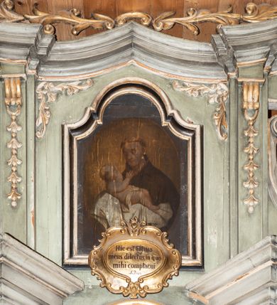 Zdjęcie nr 12: Nastawa architektoniczna, jednokondygnacyjna ze zwieńczeniem i bramkami; ustawiona na jednostopniowej podstawie. Ołtarz drewniany, prostopadłościenny, obity boazerią, mensa drewniana z kamiennym portatylem. Tabernakulum w formie drewnianej skrzynki na dwustrefowym cokole zryzalitowanym bo bokach, o lekko wklęsłej linii. Ścianka frontowa obita fakturowaną blachą; drzwiczki w formie kwadratu z aplikowanym krzyżem oraz literami: Α i Ω. Tron wystawienia w formie baldachimu podtrzymywanego przez parę skręconych kolumn oraz ścianką tylną zwieńczoną konchą; dekorowane wolutami utworzonymi z akantu i karbowanej wstęgi. W partii cokołu przejścia, flankowane skrajnie filarami, zakończonymi wyłamanym gzymsem zamykającym prześwity. 

Pole środkowe flankują dwie pary opilastrowanych filarów oraz dwie pary kolumn ustawionych pod kątem, dźwigających pełne belkowanie wyłamane na ich osi i przerwane nad polem środkowym oraz przerwany wolutowy przyczółek. W polu środkowym płytka nisza w formie stojącego prostokąta zamkniętego łukiem wklęsło-wypukłym z uskokami z obrazem Przemienienie Pańskie, ujęta profilowaną ramą. Powyżej kartusz z napisem: „Hic est Filius / meus dilectus, in quo / mihi complacui / S(ant) Joan”. Pomiędzy kolumnami figury św. Piotra po lewej stronie i św. Pawła po prawej stronie. 

Zwieńczenie w formie stojącego prostokąta ujętego pilastrami, zamkniętego gzymsem w kształcie łuku kotarowego; po bokach ujęte spływami wolutowymi. W polu środkowym obraz św. Antoniego Padewskiego, umieszczony w ramie w kształcie stojącego prostokąta zamkniętego łukiem wklęsło-wypukłym z uskokami.  Na przerwanych przyczółkach siedzące figury aniołów. W partii trzonów pilastrów kondygnacji i zwieńczenia kampanule. Pole zwieńczenia w przyłuczach oraz na spływach wolutowe zwieńczenia zdobione stylizowanym akantem. Struktura polichromowana na kolor jasnozielony, cokoły i gzymsy na kolor szary, trzony kolumn białe, ornamentyka złocona. 