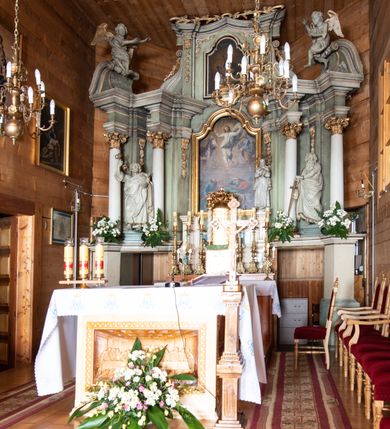 Zdjęcie nr 2: Nastawa architektoniczna, jednokondygnacyjna ze zwieńczeniem i bramkami; ustawiona na jednostopniowej podstawie. Ołtarz drewniany, prostopadłościenny, obity boazerią, mensa drewniana z kamiennym portatylem. Tabernakulum w formie drewnianej skrzynki na dwustrefowym cokole zryzalitowanym bo bokach, o lekko wklęsłej linii. Ścianka frontowa obita fakturowaną blachą; drzwiczki w formie kwadratu z aplikowanym krzyżem oraz literami: Α i Ω. Tron wystawienia w formie baldachimu podtrzymywanego przez parę skręconych kolumn oraz ścianką tylną zwieńczoną konchą; dekorowane wolutami utworzonymi z akantu i karbowanej wstęgi. W partii cokołu przejścia, flankowane skrajnie filarami, zakończonymi wyłamanym gzymsem zamykającym prześwity. 

Pole środkowe flankują dwie pary opilastrowanych filarów oraz dwie pary kolumn ustawionych pod kątem, dźwigających pełne belkowanie wyłamane na ich osi i przerwane nad polem środkowym oraz przerwany wolutowy przyczółek. W polu środkowym płytka nisza w formie stojącego prostokąta zamkniętego łukiem wklęsło-wypukłym z uskokami z obrazem Przemienienie Pańskie, ujęta profilowaną ramą. Powyżej kartusz z napisem: „Hic est Filius / meus dilectus, in quo / mihi complacui / S(ant) Joan”. Pomiędzy kolumnami figury św. Piotra po lewej stronie i św. Pawła po prawej stronie. 

Zwieńczenie w formie stojącego prostokąta ujętego pilastrami, zamkniętego gzymsem w kształcie łuku kotarowego; po bokach ujęte spływami wolutowymi. W polu środkowym obraz św. Antoniego Padewskiego, umieszczony w ramie w kształcie stojącego prostokąta zamkniętego łukiem wklęsło-wypukłym z uskokami.  Na przerwanych przyczółkach siedzące figury aniołów. W partii trzonów pilastrów kondygnacji i zwieńczenia kampanule. Pole zwieńczenia w przyłuczach oraz na spływach wolutowe zwieńczenia zdobione stylizowanym akantem. Struktura polichromowana na kolor jasnozielony, cokoły i gzymsy na kolor szary, trzony kolumn białe, ornamentyka złocona. 