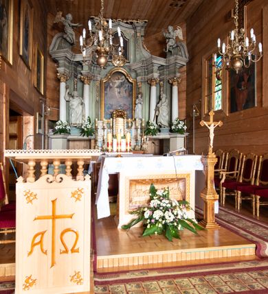 Zdjęcie nr 4: Nastawa architektoniczna, jednokondygnacyjna ze zwieńczeniem i bramkami; ustawiona na jednostopniowej podstawie. Ołtarz drewniany, prostopadłościenny, obity boazerią, mensa drewniana z kamiennym portatylem. Tabernakulum w formie drewnianej skrzynki na dwustrefowym cokole zryzalitowanym bo bokach, o lekko wklęsłej linii. Ścianka frontowa obita fakturowaną blachą; drzwiczki w formie kwadratu z aplikowanym krzyżem oraz literami: Α i Ω. Tron wystawienia w formie baldachimu podtrzymywanego przez parę skręconych kolumn oraz ścianką tylną zwieńczoną konchą; dekorowane wolutami utworzonymi z akantu i karbowanej wstęgi. W partii cokołu przejścia, flankowane skrajnie filarami, zakończonymi wyłamanym gzymsem zamykającym prześwity. 

Pole środkowe flankują dwie pary opilastrowanych filarów oraz dwie pary kolumn ustawionych pod kątem, dźwigających pełne belkowanie wyłamane na ich osi i przerwane nad polem środkowym oraz przerwany wolutowy przyczółek. W polu środkowym płytka nisza w formie stojącego prostokąta zamkniętego łukiem wklęsło-wypukłym z uskokami z obrazem Przemienienie Pańskie, ujęta profilowaną ramą. Powyżej kartusz z napisem: „Hic est Filius / meus dilectus, in quo / mihi complacui / S(ant) Joan”. Pomiędzy kolumnami figury św. Piotra po lewej stronie i św. Pawła po prawej stronie. 

Zwieńczenie w formie stojącego prostokąta ujętego pilastrami, zamkniętego gzymsem w kształcie łuku kotarowego; po bokach ujęte spływami wolutowymi. W polu środkowym obraz św. Antoniego Padewskiego, umieszczony w ramie w kształcie stojącego prostokąta zamkniętego łukiem wklęsło-wypukłym z uskokami.  Na przerwanych przyczółkach siedzące figury aniołów. W partii trzonów pilastrów kondygnacji i zwieńczenia kampanule. Pole zwieńczenia w przyłuczach oraz na spływach wolutowe zwieńczenia zdobione stylizowanym akantem. Struktura polichromowana na kolor jasnozielony, cokoły i gzymsy na kolor szary, trzony kolumn białe, ornamentyka złocona. 