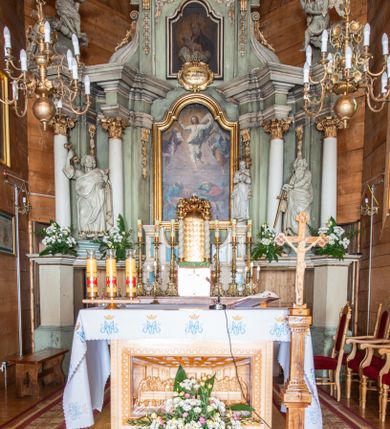 Zdjęcie nr 3: Nastawa architektoniczna, jednokondygnacyjna ze zwieńczeniem i bramkami; ustawiona na jednostopniowej podstawie. Ołtarz drewniany, prostopadłościenny, obity boazerią, mensa drewniana z kamiennym portatylem. Tabernakulum w formie drewnianej skrzynki na dwustrefowym cokole zryzalitowanym bo bokach, o lekko wklęsłej linii. Ścianka frontowa obita fakturowaną blachą; drzwiczki w formie kwadratu z aplikowanym krzyżem oraz literami: Α i Ω. Tron wystawienia w formie baldachimu podtrzymywanego przez parę skręconych kolumn oraz ścianką tylną zwieńczoną konchą; dekorowane wolutami utworzonymi z akantu i karbowanej wstęgi. W partii cokołu przejścia, flankowane skrajnie filarami, zakończonymi wyłamanym gzymsem zamykającym prześwity. 

Pole środkowe flankują dwie pary opilastrowanych filarów oraz dwie pary kolumn ustawionych pod kątem, dźwigających pełne belkowanie wyłamane na ich osi i przerwane nad polem środkowym oraz przerwany wolutowy przyczółek. W polu środkowym płytka nisza w formie stojącego prostokąta zamkniętego łukiem wklęsło-wypukłym z uskokami z obrazem Przemienienie Pańskie, ujęta profilowaną ramą. Powyżej kartusz z napisem: „Hic est Filius / meus dilectus, in quo / mihi complacui / S(ant) Joan”. Pomiędzy kolumnami figury św. Piotra po lewej stronie i św. Pawła po prawej stronie. 

Zwieńczenie w formie stojącego prostokąta ujętego pilastrami, zamkniętego gzymsem w kształcie łuku kotarowego; po bokach ujęte spływami wolutowymi. W polu środkowym obraz św. Antoniego Padewskiego, umieszczony w ramie w kształcie stojącego prostokąta zamkniętego łukiem wklęsło-wypukłym z uskokami.  Na przerwanych przyczółkach siedzące figury aniołów. W partii trzonów pilastrów kondygnacji i zwieńczenia kampanule. Pole zwieńczenia w przyłuczach oraz na spływach wolutowe zwieńczenia zdobione stylizowanym akantem. Struktura polichromowana na kolor jasnozielony, cokoły i gzymsy na kolor szary, trzony kolumn białe, ornamentyka złocona. 