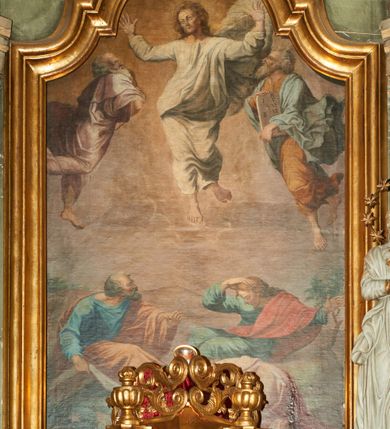 Zdjęcie nr 1: Obraz w kształcie stojącego prostokąta zamkniętego łukiem wklęsło-wypukłym z uskokami, ukazujący scenę Przemienienia Pańskiego na górze Tabor. U góry, pośrodku kompozycji pośród obłoków ukazany jest Chrystus z szeroko rozłożonymi rękami, głową przechyloną w prawą stronę i lewą nogą ugiętą w kolanie. Twarz podłużna z długim nosem, małymi ustami i dużymi oczami ze wzrokiem skierowanym do góry. Wokół głowy bujne i długie włosy. Chrystus ubrany jest w białą suknię oraz biały płaszcz. Po prawej stronie Zbawiciela stoi prorok Eliasz, a po lewej Mojżesz, obaj zwróceni w stronę Chrystusa. Eliasz ubrany jest w jasnoróżowe szaty (suknię i płaszcz), natomiast Mojżesz w brązową suknię i jasnoniebieski płaszcz. Obaj mają twarze o rysach starszych mężczyzn z siwymi włosami oraz długimi, siwymi brodami. Mojżesz ma na głowie dwa złote rogi, a w dłoniach trzyma tablice dekalogu z cyframi rzymskimi. W dolnej strefie kompozycji na tle wzniesienia ukazani są w poruszonych pozach św. Jan Ewangelista, św. Piotr oraz św. Jakub. Święty Piotr, przedstawiony po lewej stronie ubrany jest w błękitną suknię i brązowy płaszcz. Po prawej stronie siedzi św. Jan Ewangelista z długimi włosami, ubrany w zieloną suknię oraz czerwony płaszcz. Natomiast pośrodku znajduje się św. Jakub w jasnofioletowym płaszczu. Wszyscy o fizjonomiach dla nich charakterystycznych w ikonografii chrześcijańskiej: św. Jan – o fizjonomii młodzieńca z długimi włosami, a św. Piotr – z krótkimi i siwymi włosami oraz krótką brodą. W oddali widać górski krajobraz. Rama drewniana, profilowana i pozłacana.