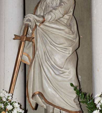 Zdjęcie nr 3: Rzeźba ścięta z tyłu, drążona, przedstawiająca św. Pawła. Święty ukazany jest w postawie stojącej z prawą nogą wysuniętą do przodu o esowato wygiętej sylwetce z dłońmi opartymi o miecz przy prawym boku. Twarz podłużna, okolona długą brodą, nos długi, głęboko osadzone oczy i wyraźnie zaznaczone kości policzkowe i łuki brwiowe. Włosy średniej długości, bujne. Święty ubrany jest w długą suknię oraz płaszcz zarzucony na prawe ramię i biegnący pod lewą ręką na prawe przedramię. Szaty na brzegach zdobione są złotą lamówką. Rzeźba polichromowana jest w całości na biało, atrybuty i brzeg szaty złocone. Rzeźba ustawiona jest na wysokim, prostopadłościennym cokole, zwężonym pośrodku, bogato profilowanym, polichromowanym na kolor jasnozielony.