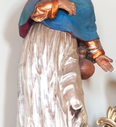 Zdjęcie nr 7: Ołtarz przyścienny, architektoniczny, jednoosiowy, jednokondygnacyjny ze zwieńczeniem. Ołtarz skrzyniowy, antepedium drewniane z wydzielonym polem w kształcie lezącego ośmioboku z dekoracją w formie marmoryzacji. Mensa drewniana, polichromowana. Retabulum ustawione na wysokim, zdwojonym cokole, ujęte parą kolumn korynckich wspierających przerwane, wyłamujące się belkowanie z profilowanym, silnie wysuniętym gzymsem. Zwieńczenie o formie wklęsło-wypukłej, flankowane spływami wolutowymi. Prostokątne pola cokołów kolumn dekorowane motywem roślinnym. Pole środkowe w formie prostokątnej wnęki zamkniętej fantazyjnym łukiem nadwieszonym ujętym stylizowanymi motywami roślinnymi, z dwoma uskrzydlonymi główkami aniołków pośrodku. Wewnątrz figura Matki Boskiej Niepokalanie Poczętej. W zwieńczeniu po bokach dwie pełnoplastyczne figury świętych (po lewej św. Jakub Większy z bukłakiem u boku), w polu motyw serca przeszytego mieczem boleści, ujętego okręgiem obłoków i promieni. Powyżej na gzymsie figurka anioła. Polichromia całości struktury w kolorze kremowym. Pola płycin, kolumny, elementy belkowania, obramienie niszy marmoryzowane. Detal architektoniczny i ornamenty złocone i srebrzone.  
