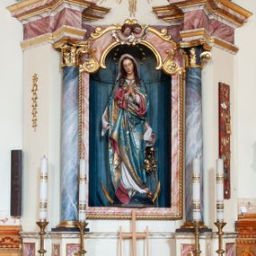 Zdjęcie nr 1: Ołtarz przyścienny, architektoniczny, jednoosiowy, jednokondygnacyjny ze zwieńczeniem. Ołtarz skrzyniowy, antepedium drewniane z wydzielonym polem w kształcie lezącego ośmioboku z dekoracją w formie marmoryzacji. Mensa drewniana, polichromowana. Retabulum ustawione na wysokim, zdwojonym cokole, ujęte parą kolumn korynckich wspierających przerwane, wyłamujące się belkowanie z profilowanym, silnie wysuniętym gzymsem. Zwieńczenie o formie wklęsło-wypukłej, flankowane spływami wolutowymi. Prostokątne pola cokołów kolumn dekorowane motywem roślinnym. Pole środkowe w formie prostokątnej wnęki zamkniętej fantazyjnym łukiem nadwieszonym ujętym stylizowanymi motywami roślinnymi, z dwoma uskrzydlonymi główkami aniołków pośrodku. Wewnątrz figura Matki Boskiej Niepokalanie Poczętej. W zwieńczeniu po bokach dwie pełnoplastyczne figury świętych (po lewej św. Jakub Większy z bukłakiem u boku), w polu motyw serca przeszytego mieczem boleści, ujętego okręgiem obłoków i promieni. Powyżej na gzymsie figurka anioła. Polichromia całości struktury w kolorze kremowym. Pola płycin, kolumny, elementy belkowania, obramienie niszy marmoryzowane. Detal architektoniczny i ornamenty złocone i srebrzone.  
