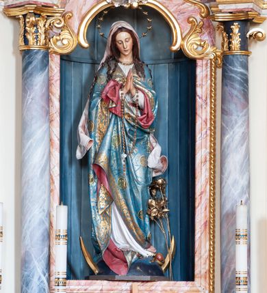 Zdjęcie nr 5: Ołtarz przyścienny, architektoniczny, jednoosiowy, jednokondygnacyjny ze zwieńczeniem. Ołtarz skrzyniowy, antepedium drewniane z wydzielonym polem w kształcie lezącego ośmioboku z dekoracją w formie marmoryzacji. Mensa drewniana, polichromowana. Retabulum ustawione na wysokim, zdwojonym cokole, ujęte parą kolumn korynckich wspierających przerwane, wyłamujące się belkowanie z profilowanym, silnie wysuniętym gzymsem. Zwieńczenie o formie wklęsło-wypukłej, flankowane spływami wolutowymi. Prostokątne pola cokołów kolumn dekorowane motywem roślinnym. Pole środkowe w formie prostokątnej wnęki zamkniętej fantazyjnym łukiem nadwieszonym ujętym stylizowanymi motywami roślinnymi, z dwoma uskrzydlonymi główkami aniołków pośrodku. Wewnątrz figura Matki Boskiej Niepokalanie Poczętej. W zwieńczeniu po bokach dwie pełnoplastyczne figury świętych (po lewej św. Jakub Większy z bukłakiem u boku), w polu motyw serca przeszytego mieczem boleści, ujętego okręgiem obłoków i promieni. Powyżej na gzymsie figurka anioła. Polichromia całości struktury w kolorze kremowym. Pola płycin, kolumny, elementy belkowania, obramienie niszy marmoryzowane. Detal architektoniczny i ornamenty złocone i srebrzone.  
