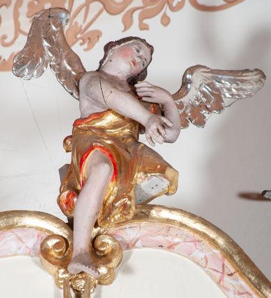 Zdjęcie nr 3: Ołtarz przyścienny, architektoniczny, jednoosiowy, jednokondygnacyjny. Mensa drewniana o formach wklęsło-wypukłych; na licu płycina w formie leżącego prostokąta o ściętych narożach wypełniona marmoryzacją. Tabernakulum dwudrzwiczkowe, zamknięte łukiem pełnym, ujęte dwiema  kolumienkami o kompozytowych kapitelach. W zwieńczeniu ażurowa, złocona dekoracja w formie przeciwstawnie ustawionego akantu z palmetą na osi. Na drzwiczkach płaskorzeźbione kłosy oraz winne grona. Retabulum na wysokim cokole ujęte ustawionymi ukośnie kolumnami o kompozytowych kapitelach i marmoryzowanych trzonach umiejscowionymi na wysokich postumentach (lica zdobione marmoryzowanymi płycinami  wypełnioymi rocaille&#039;m). Podpory dźwigają odcinki pełnego, wyłamanego belkowania zwieńczonego wydatnym, silnie profilowanym gzymsem. Na belkowaniu, na osiach kolumn pełnoplastyczne figury niezidentyfikowanych świętych z krzyżem w ręku (z lewej, św. Jan Nepomucen?) oraz z księgą (z prawej). W polu centralnym nisza zamknięta u góry łukiem o falistym zarysie utworzonym przez dwie przeciwstawnie ustawione woluty. Nisza mieści pełnoplastyczną figurę Chrystusa z gorejącym sercem. Ponad nią, a osi dwie płaskorzeźbione uskrzydlone główki anielskie. Zwieńczenie o wolutowo wyciętych bokach zamknięte łukiem wklęsło-wypukłym. W polu płaskorzeźbione przedstawienie gorejącego serca w srebrzonym medalionie z obłoków oraz glorii promienistej o alternowanych promieniach. Powyżej na osi, pełnoplastyczna figura uskrzydlonego anioła. Po bokach wota i kampanule. Struktura malowana na kolor jasnobeżowy. Marmoryzacja w odcieniach różu. Ornamentyka oraz załamania profili architektonicznych złocone.